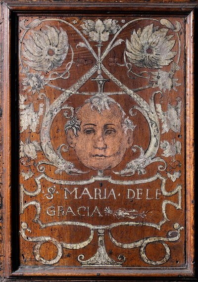 Piatto di legno decorato con un volto e l