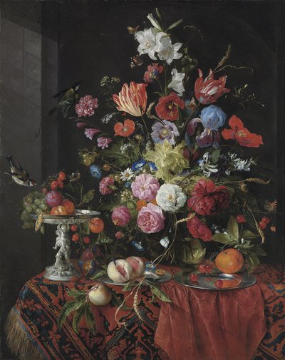 Fiori in un vaso di vetro su un tavolo drappeggiato, con una tazza d