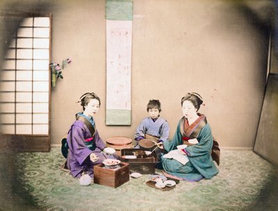 Due donne e un bambino pranzano seduti su una stuoia, c.1890 da Japanese Photographer