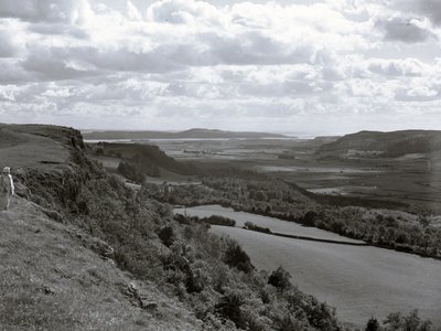 Una signora in piedi sul pendio di una collina che guarda il paesaggio di Scout Scar da Joseph Hardman