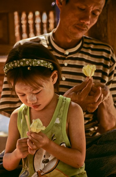 Padre e figlia sieropositivi che fanno fiori di carta, 2002 (foto) da Karen Kasmauski