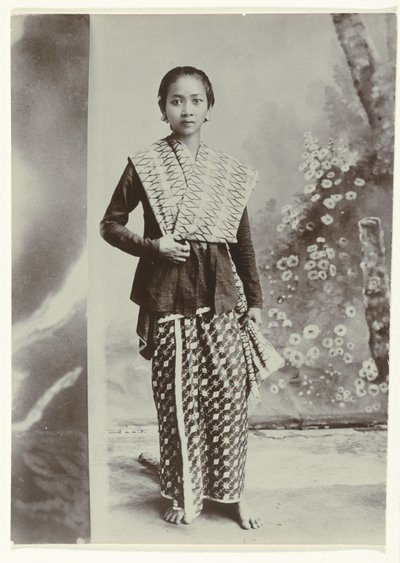 Ritratto in studio di una giovane donna giavanese in un sarong con motivo batik e una camicia a quadretti da Kassian Cephas