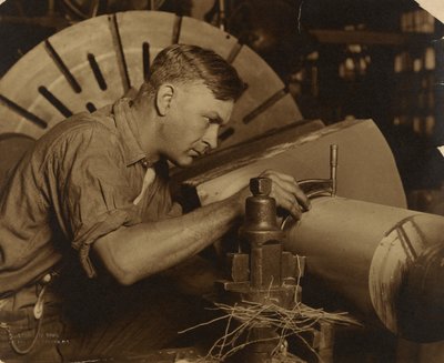 Uomo con micrometro che misura un albero al millesimo di pollice. da Lewis W. Hine