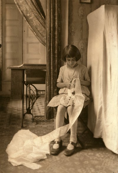 Una giovane ragazza che taglia il pizzo a casa sua a New York City da Lewis Wickes Hine