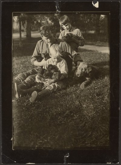 [Uomo con bambini e cuccioli in cortile] da Louis Fleckenstein