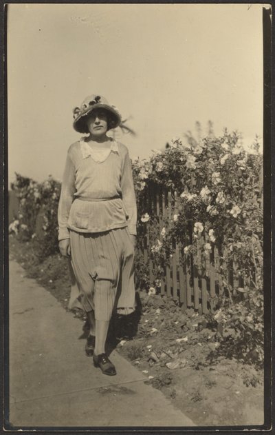 [Donna che cammina lungo la staccionata con i fiori] da Louis Fleckenstein