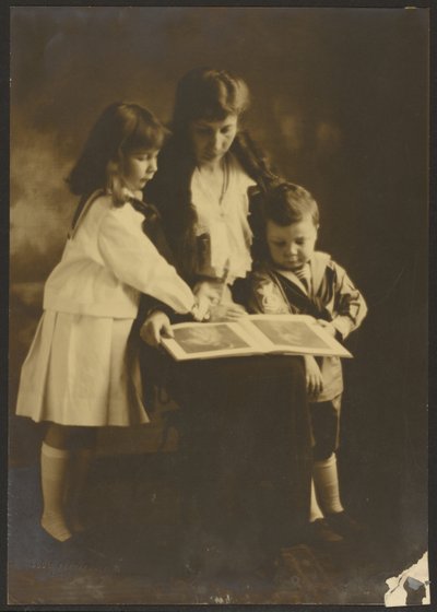 [Donna e bambini con libro illustrato] da Louis Fleckenstein