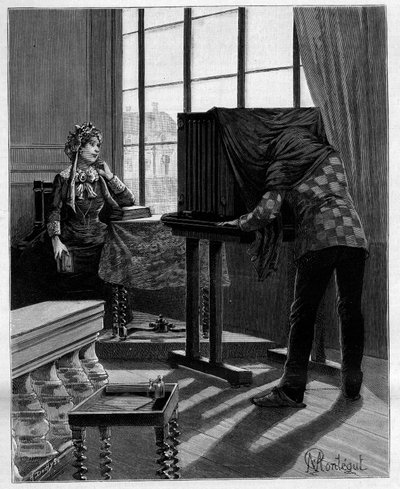 E senza alcun cattivo umore, la signora del Midi rimette il gomito sul tavolo e il mento nella mano. Fotografo nel suo studio che scatta una fotografia con una camera oscura. In 