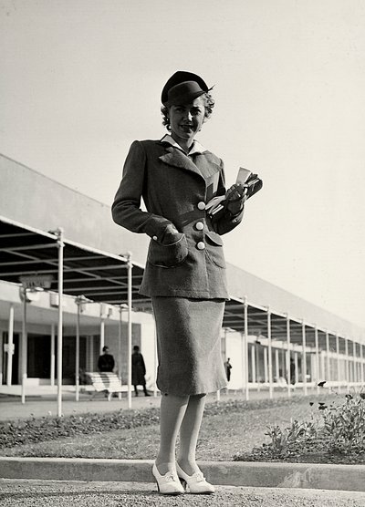 Modella in un completo creato dalla casa di moda "Graldi". Un cappello rigido completa l