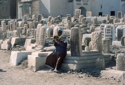 Uomo yemenita recita il Corano nel cimitero con tombe a Sayun, Hadramawt, Yemen del Sud. da Lynn Abercrombie