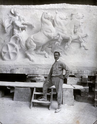Ritratto a figura intera del famoso scultore Pietro Canonica. Sta posando nel suo studio davanti a un altorilievo in marmo su cui sta lavorando da Mario Nunes Vais