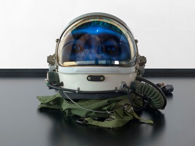 Alpha Omega, 2016 (vetro, schermo LCD, lettore multimediale, teschio replicato, casco spaziale, legno) da Mat Collishaw