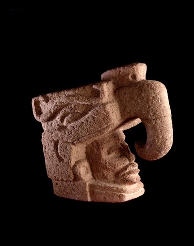 Arte precolombiana, civiltà Maya, periodo preclassico: scultura in pietra che raffigura la testa di un uomo che emerge dalla bocca di un dio zoomorfo simile all