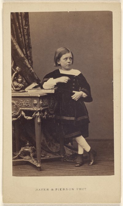 [Bambina non identificata, in piedi, con il gomito sopra un libro chiuso su un tavolo]. da Mayer and Pierson