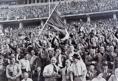 Tifosi italiani che sostengono i loro atleti nello stadio ai Giochi Olimpici, Berlino, Germania da Photographer German