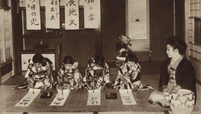 Scolare giapponesi che scrivono con pennelli in una classe di asilo da Photographer Japanese