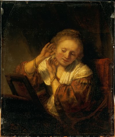 Giovane donna che si adorna con orecchini da Rembrandt van Rijn