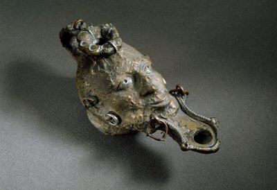 Arte romana: lampada ad olio in bronzo a forma di volto. I-II secolo d.C. Spagna, Museo di Ampurias (Empurias) da Roman