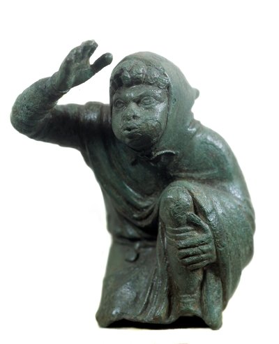 Arte romana: statuetta in bronzo di schiavo nero inginocchiato e soffiando da Roman