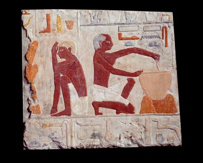Arte egizia antica: fare il pane. Un uomo prepara la pasta per le torte, un altro controlla la cottura degli stampi per il pane. Calcare (2500-2350 a.C.) V dinastia. Parigi, Museo del Louvre da School Egyptian