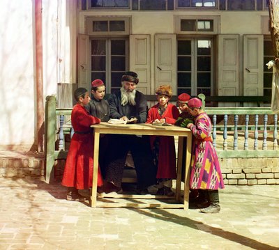 Un gruppo di bambini ebrei con un insegnante su un tavolo davanti a una casa, Samarcanda, Impero Russo, tra il 1905 e il 1915 da Sergey Prokudin Gorsky
