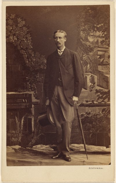 [Uomo non identificato con baffi, cappello a cilindro e ombrello in mano, in piedi]. da Southwell Brothers