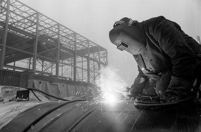 Saldatore usa una torcia ad acetilene per saldare tubi industriali nel cantiere delle operazioni di Hanford da Ted Spiegel