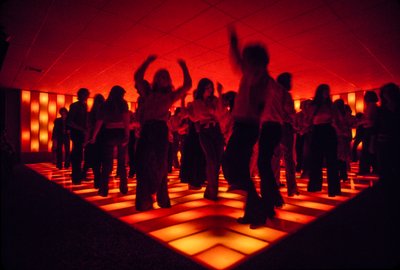 Giovani ballerini in una discoteca che ballano su un pavimento illuminato da Ted Spiegel