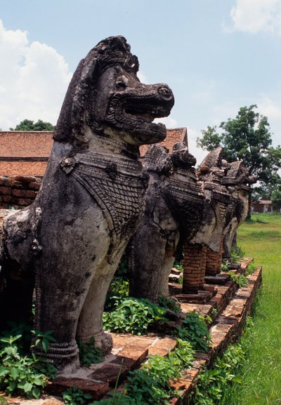 Figure di guardiani in pietra simili a leoni costruite intorno alla base dello stupa da Thai School