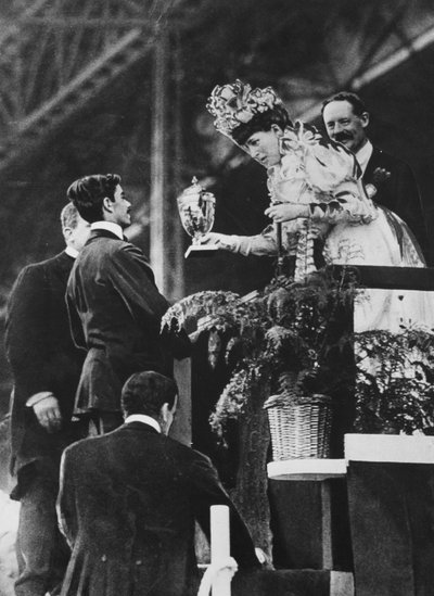 La Regina Alessandra che consegna una coppa speciale a Dorando per commemorare il suo grande sforzo per vincere la maratona olimpica nel luglio 1908 da Thomas E. and Horace Grant Grant
