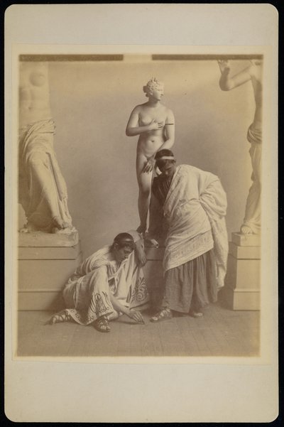 [Due studenti maschi in costume greco davanti a un calco di Afrodite nella sala dei calchi dell