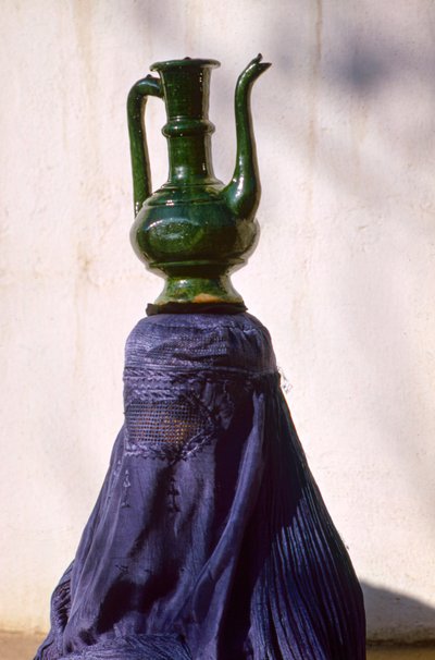 Donna a Kabul nascosta alla vista da un chadri di seta aka chador che trasporta una brocca da Thomas J. Abercrombie