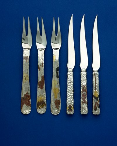 Parte di un set fine e raro di 36 coltelli e forchette da dessert, i manici martellati a punti intarsiati con rame patinato e oro variegato, con dettagli incisi di vari disegni floreali, animali e geometrici, c.1880 da Tiffany and Company