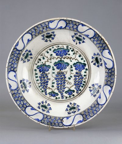 Un piatto di ceramica Iznik, con un medaglione centrale che raffigura tre grappoli d
