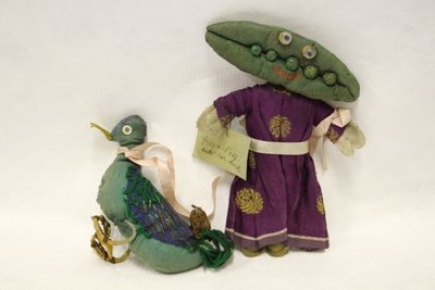 Bambola di pezza Miss Green Peas, testa a forma di baccello di pisello, conduce il suo anatroccolo con un nastro di raso rosa da Una Maw