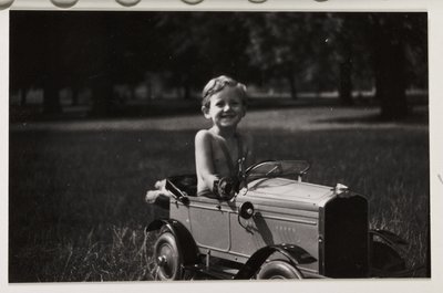Ragazzo che guida una macchina a pedali giocattolo, c 1930 da Unbekannt