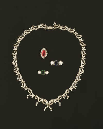 Collana a rotolo e foglia Art Deco; anello a grappolo in rubini e diamanti; anello a tre pietre in zaffiro e diamanti; anello a tre pietre in smeraldo e diamanti da Unbekannt Unbekannt