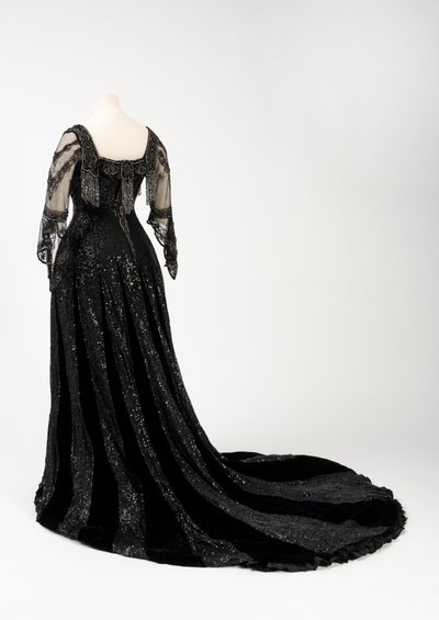 Abito da sera nero indossato dalla regina Alessandra, con decorazioni di perline e paillettes e incorporante il nastro di seta nera e lettere dorate con il nome della regina Alessandra, realizzato da Barolet di Knightsbridge, Londra 1908-1910 da Unbekannt