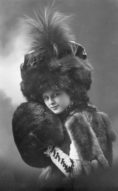 Moda: una giovane donna in pelliccia (cappotto, cappello piumato e manica). Anni 1920-1930 Fotografia storica di moda, modella femminile da Unbekannter Künstler