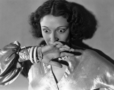 Hollywood, California: c.1932 Primo piano di una giovane donna che si copre la bocca per la paura. (foto b/n) da Unbekannt