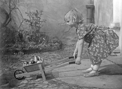 Bambina che gioca con una carriola. Fotografia intorno al 1931 da Unbekannt