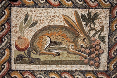 Mosaico che rappresenta una lepre con uno sguardo sospettoso che bruca un grappolo d