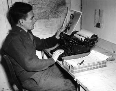 Seconda Guerra Mondiale (1939-1945): Mutzig (Alsazia) Francia 1 dicembre 1944: Il caporale Flanerty cronista del Beachead News guarda una fotografia di pin-up che pubblicherà nel prossimo numero del giornale. da Unbekannt