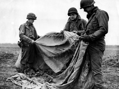 Seconda Guerra Mondiale (1939-1945): Vicino a Kornelmunster (Germania) 17 dicembre 1944: I fanti della 1ª Armata statunitense esaminano un paracadute tedesco usato la notte prima del giorno dell