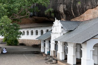 Edificio bianco sotto una parete rocciosa; tempio rupestre; Tempio d
