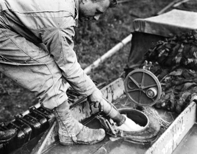 Seconda Guerra Mondiale: Normandia, Francia, estate 1944: In una stazione di stoccaggio del gas, un soldato di una compagnia di trasporto degli Stati Uniti rifornisce di carburante il serbatoio di un