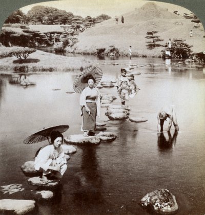 Donne che attraversano il lago su pietre, Giardino Suizen-ji, Kumamoto, Giappone, 1904 da Underwood and Underwood
