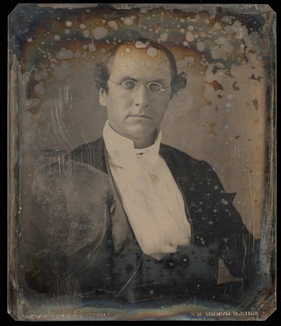 [Ritratto di un uomo seduto che indossa occhiali ovali con montatura a filo]. da Unknown artist