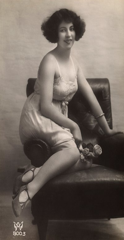 Una giovane donna che posa in sottoveste, seduta in una poltrona da Unknown photographer