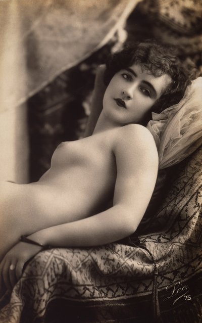 Una giovane donna che posa nuda su un divano da Unknown photographer